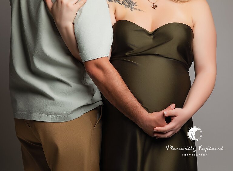 Close-up maternity portrait highlighting hands on baby bump