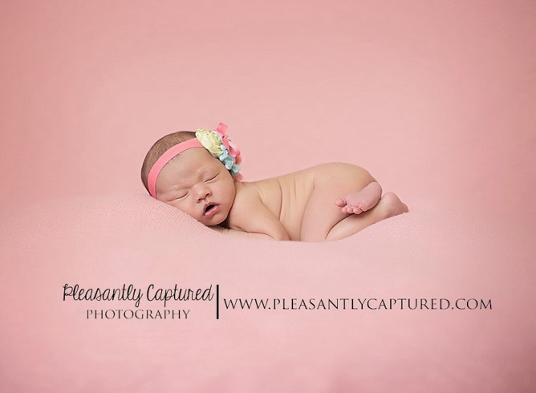 Newborn girl in tushie pose wearing blue, pink and green headband - Newborn baby photography jacksonville NC wilmington NC