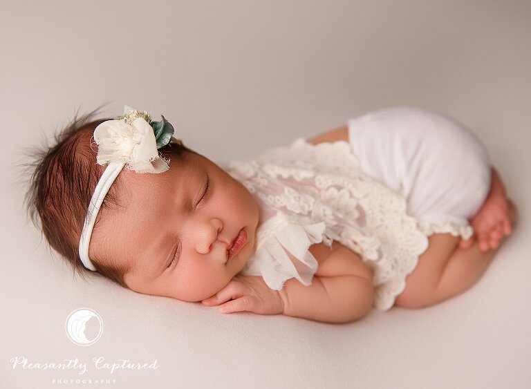 Newborn baby girl wearing lace shirt and white bow - Baby Sister Makes 4 | Richlands Newborn Photography