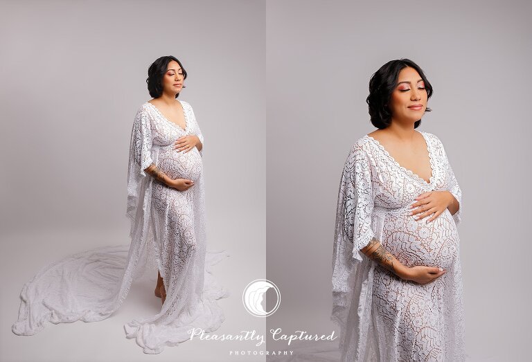 Pregnant mother wearing white dress and holding belly at nc maternity photographer studio
