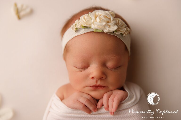newborn girl closeup in neutral white wrap and flower headband - Sneads Ferry Newborn Photography | New Family of 3