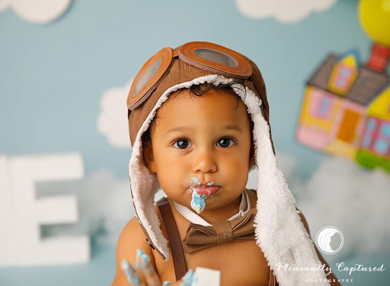 boy with frosting on his face Up Themed Cake Smash | Birthday Photography Jacksonville NC