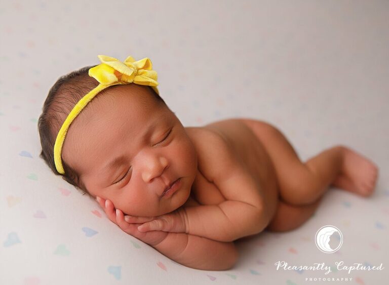 Newborn baby girl wearing yellow headband on multicolor heart blanket - richlands nc Newborn photographer