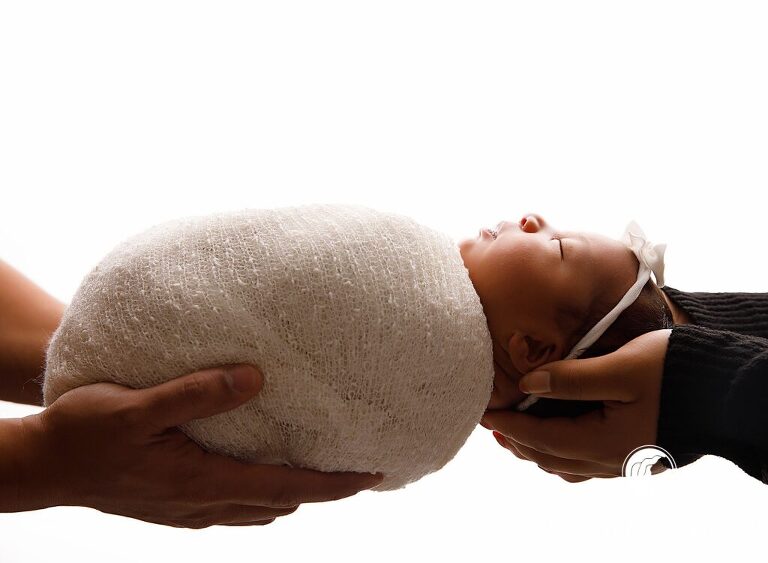 Parents hands holding baby who is wrapped up - richlands nc Newborn photographer