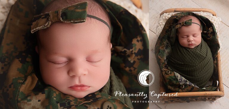 Newborn baby wrapped in military camouflage uniform with matching bow during studio session in Jacksonville, NC