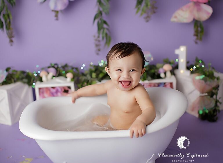 Baby girl milestone session with butterfly garden cake smash and bubble bath finale in Jacksonville, NC.